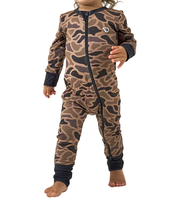 Child wearing a brown camouflage onesie with black accents on a white background