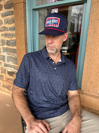 Man wearing a blue cap and shirt standing outside a building.
