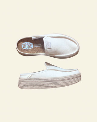 White slip-on shoes with textured sole on a beige background