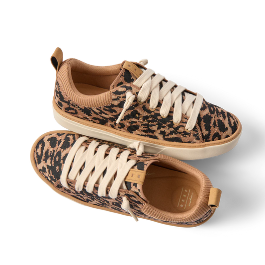 Pair of leopard print sneakers with beige accents on a white background