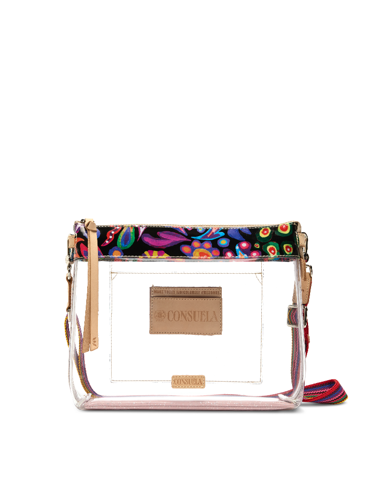 A clear plastic crossbody bag with a colorful patterned top band, gold-tone hardware, and a tan leather brand patch on the front.