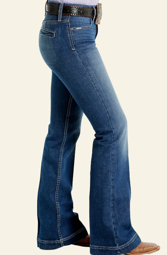 A pair of medium stone denim Cinch Lynden jeans on a female model, featuring a wide leg cut and high waist.