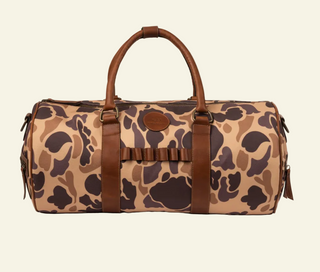 A camouflage patterned duffle bag with leather details and brown straps.