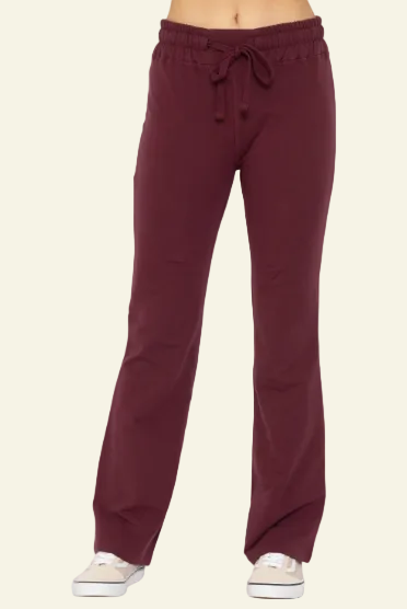 Maroon sweatpants worn by a person on a white background