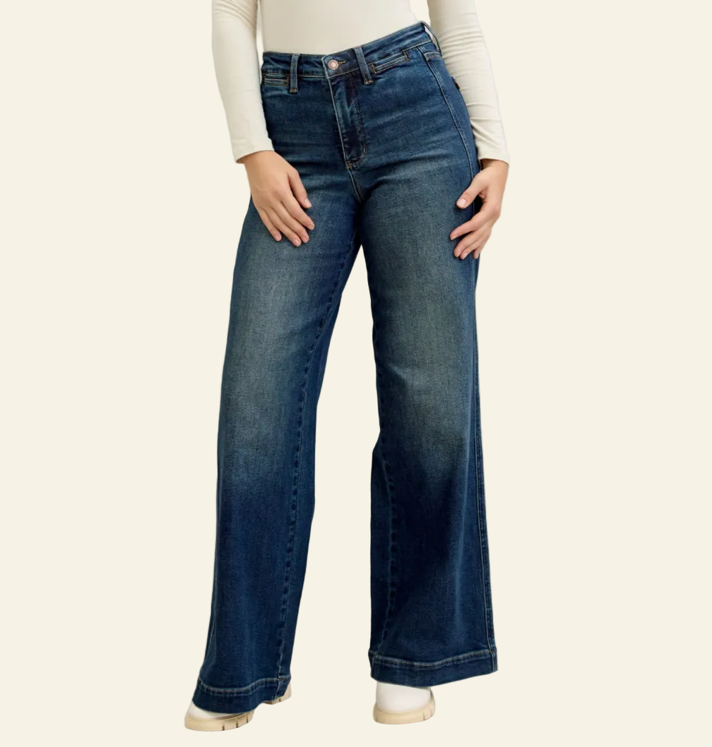 Person wearing blue flared jeans on a plain background