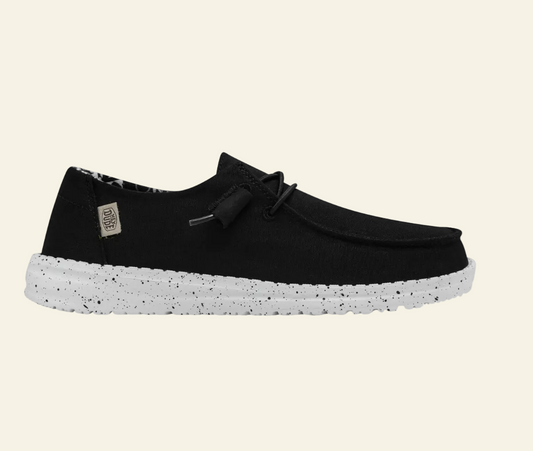 Black shoe with speckled sole on a white background