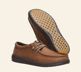 Brown leather shoe with a textured sole on a white background
