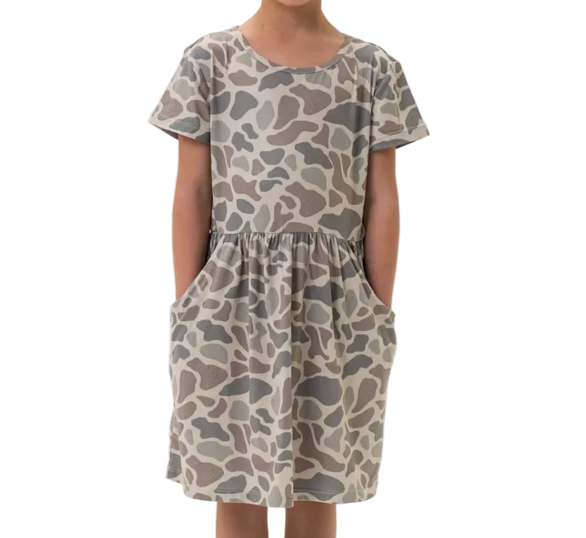 Child wearing a patterned dress on a white background