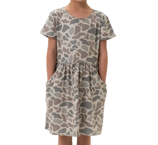 Child wearing a patterned dress on a white background