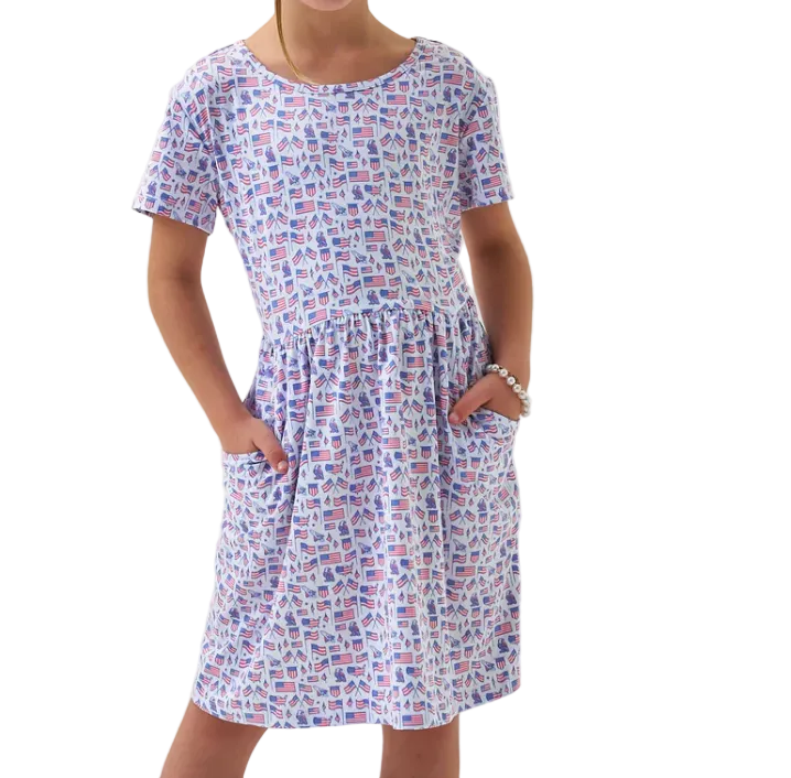 Girl wearing a flag and American theme patterned dress on a white background