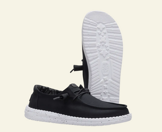 Black casual shoe with white sole on a white background