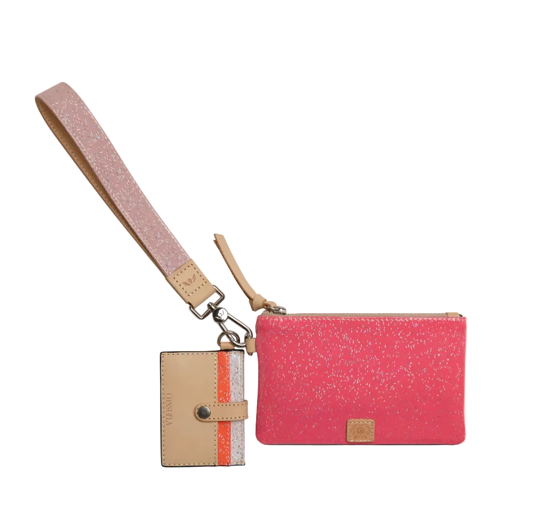 A pink glitter wristlet pouch with a matching pink wrist strap and a beige card holder tag featuring a vertical orange stripe, shown on a plain white background.